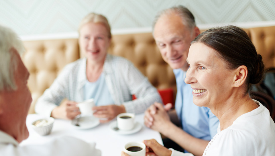 friends enjoying coffee at booth table