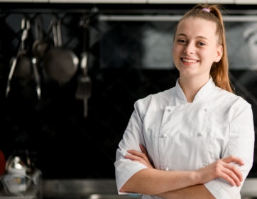 smilng young woman in a chef's jacket