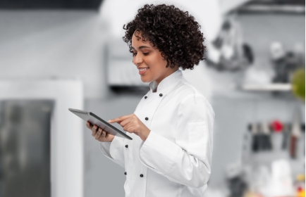 a food protection manager checking over food prep on a tablet