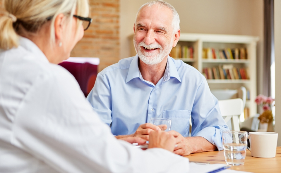 a smiling senior man speaking with a dietitian