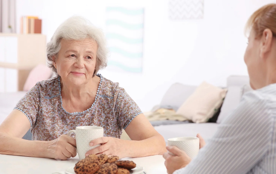 Woman drinking coffee with company.