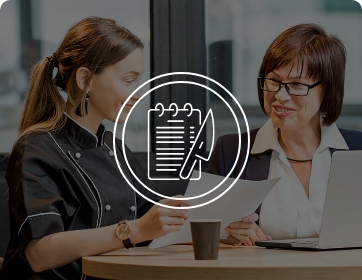 two women reviewing food menu at table